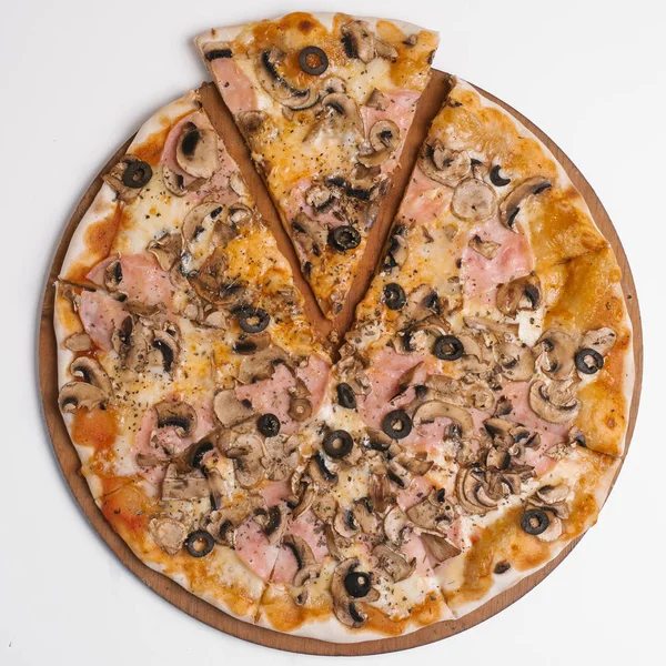 Pizza with tomato sauce, mozzarella, ham, olives and mushrooms served on wooden pizza plate