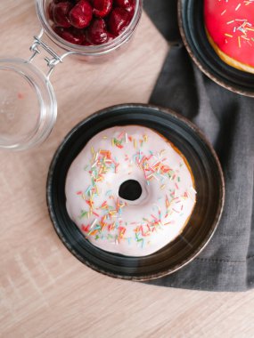 Beyaz ve kırmızı donuts kavanoz ve gri peçeteye kiraz ile servis