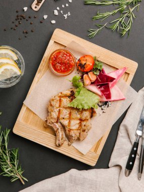 Parşömen kağıtları, limonata, bıçak ve çatal ile ahşap yemek ızgara domuz karnabahar, marul, domates, sarımsak ve Barbekü sos ile servis