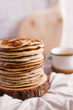 Closeup sawed ahşap bardak çay, peçete ve ahşap masa üzerinde kesme tahtası ile yığılı krep