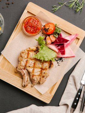 Parşömen kağıtları, limonata, bıçak ve çatal ile ahşap yemek ızgara domuz karnabahar, marul, domates, sarımsak ve Barbekü sos ile servis