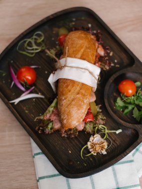 Biber, marul fırında baget ile dilimlenmiş jambon, pastırma, turşu, domates, sarımsak, tatlı soğan ve maydanoz ile ahşap yemek servis