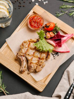 Parşömen kağıtları, limonata, bıçak ve çatal ile ahşap yemek iştah açıcı rilled domuz karnabahar, marul, domates, sarımsak ve Barbekü sos ile servis.