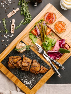 «Ana sayfa» görünümü sebzeli ızgara domuz fileto, ketçap ve Barbekü sos ahşap tabak çatal, bıçak ve peçete ile