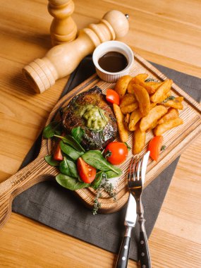 derin kızarmış patates, taze domates ve Ahşap doğrama tahtası üzerinde soya sos ile ıspanak ile kavrulmuş et