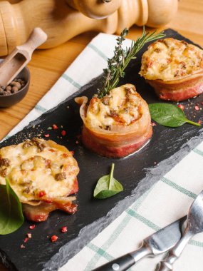 Pastırma rolls sebze ve peynir ile taş çatal ve bıçak ile tabakta