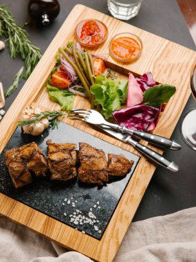 Apetisant domuz filetosu sebzeli ızgara, ketçap ve Barbekü hizmet üzerinde ahşap tabak çatal ile sos