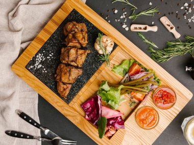 «Ana sayfa» görünümü sebzeli ızgara domuz fileto, ketçap ve Barbekü sos ahşap tabak çatal, bıçak ve peçete ile