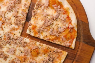 Ahşap pizza tabakta domates sosu, peynir ve ton balığı ile dilimlenmiş pizza closeup 