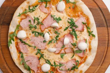 Pizza domates sosu, peynir, jambon ve roka ile closeup ahşap pizza tabakta 