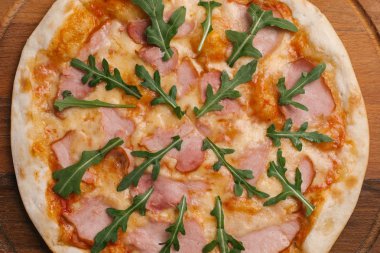 Ahşap pizza tabakta Pizza domates sosu, peynir, jambon ve roka ile Görünümü Kapat 