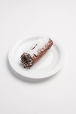 Pasta krema, çikolata ve beyaz tabakta pudra şekeri