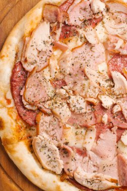 Ahşap pizza tabakta closeup biberli, jambon, tavuk ve mozzarella peynirli pizza