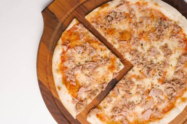 Ahşap pizza tabakta domates sosu, peynir ve ton balığı ile dilimlenmiş pizza closeup 