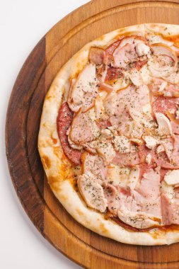 Ahşap pizza tabakta closeup biberli, jambon, tavuk ve mozzarella peynirli pizza