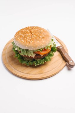 Çizburger closeup ahşap tabak üzerinde bıçak ile hizmet.