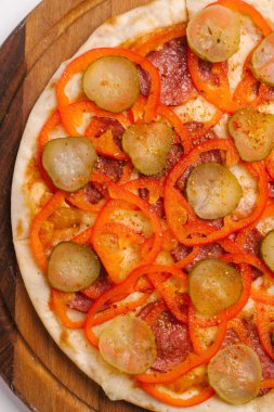 Biberli, turşu ve tatlı biber pizza closeup ahşap pizza tabakta