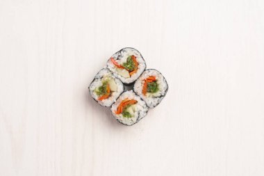 Maki sushi tatlı biber, salatalık ve bej ahşap yüzeyde hizmet yosunlar Üstten Görünüm
