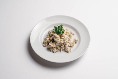 Peynir, tavuk, ananas ve soğan salatası izole beyaz arka plan üzerinde beyaz tabakta servis