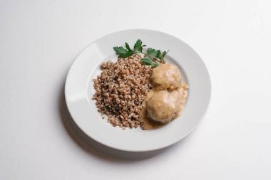 Beyaz arka plan üzerinde izole beyaz tabakta buğday Beşamel sos ve mantar sosu ile servis