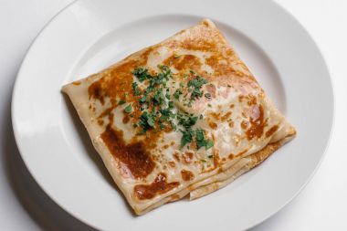 Kıyılmış maydanoz ile doldurulmuş krep closeup izole beyaz arka plan üzerinde beyaz tabakta servis