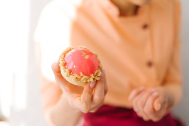 Pembe sırlı tatlı tutan el closeup