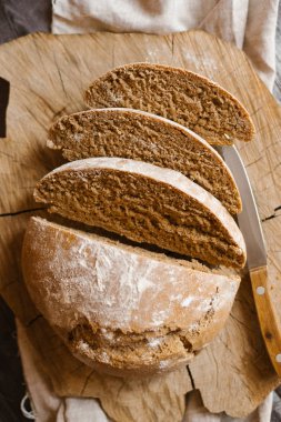 Ayrıntı görünümü dilimlenmiş ekmek sawed ahşap ve peçete üzerinde bıçak ahşap masa ile servis