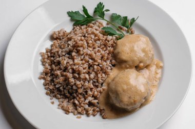 Beyaz arka plan üzerinde izole beyaz tabakta closeup buğday Beşamel sos ve mantar sosu ile servis