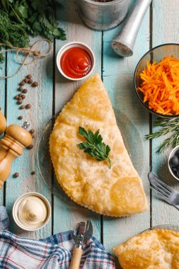 Maydanoz ile süslenmiş chebureks closeup cam tabak mayonez, ketcup, taşlama ve dilimlenmiş havuç ile mavi ahşap masa üzerinde yılları arasında görev yapmıştır