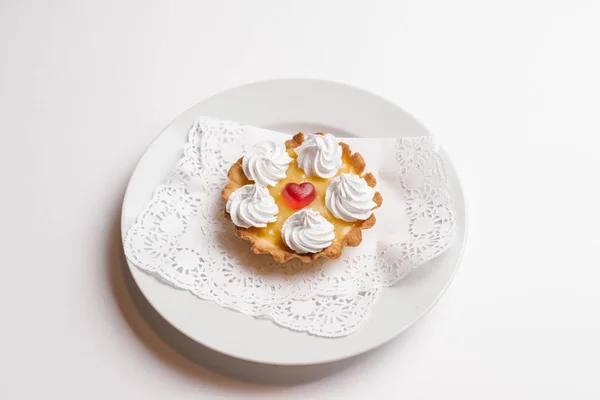 果挞与糖果和生奶油在白色板上被隔绝白色背景 — 图库照片