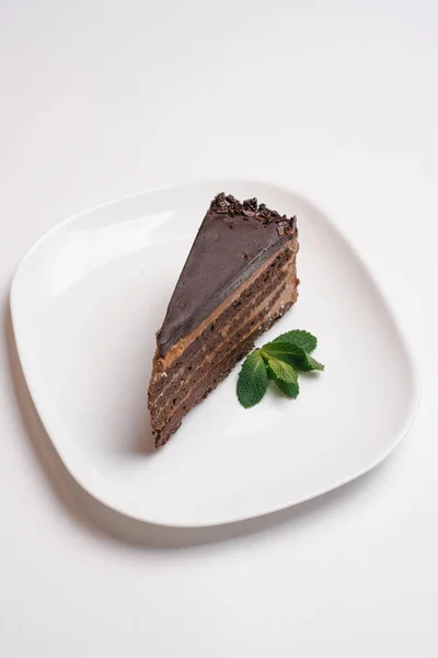 Torta Glassata Cioccolato Con Foglie Menta Servita Piatto Bianco Isolato — Foto Stock