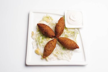 Derin kızarmış falafels marul ve beyaz tabakta sos ile