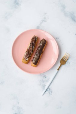 Pembe plaka üzerinde çikolata eklerleri mermer yüzeyi altın çatal ile