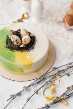 Ahşap plaka ve bej mermer yüzeyi ile yumurta, kağıt ve Söğüt dalları kesip peçeteye camlı pasta üstüne yumurtalı bileşimi gıda hizmet