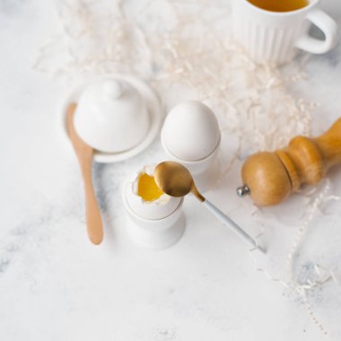 Haşlanmış yumurta yumurta sahipleri, kaşık, karabiber öğütücüsü ve çay Gıda kompozisyonu