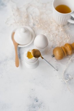 Haşlanmış yumurta yumurta sahipleri, kaşık, karabiber öğütücüsü ve çay Gıda kompozisyonu