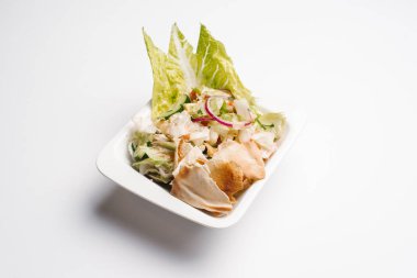 Beyaz kase içinde marul ve ekmek ile servis lezzetli sebze salatası