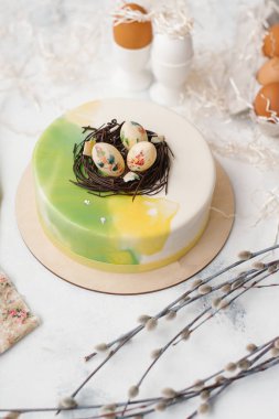 Yumurta, bej renkli peçete, kesilmiş kağıt ve Söğüt dalları ile sırlı kek Gıda kompozisyonu 