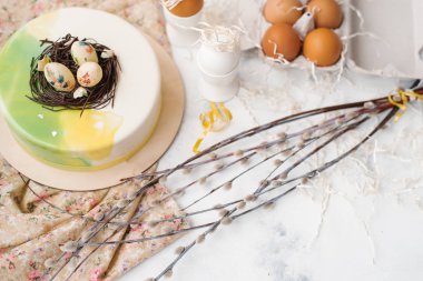 Ahşap plaka ve bej mermer yüzeyi ile yumurta, kağıt ve Söğüt dalları kesip peçeteye camlı pasta üstüne yumurtalı bileşimi gıda hizmet