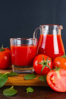 Taze domates suyu ve domates ahşap bir masa üzerinde