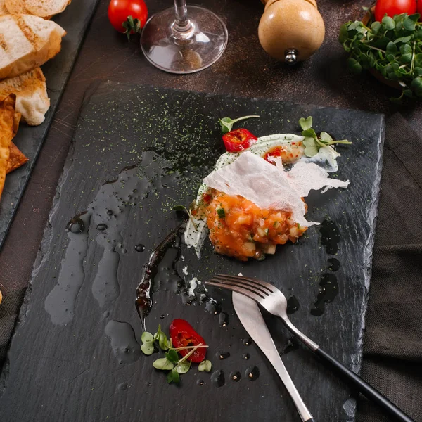 lezzetli Somon tartar salata siyah taş kayrak üzerinde görmek 