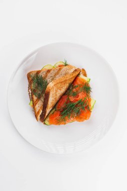 Beyaz tabakta somonlu sandviç. 