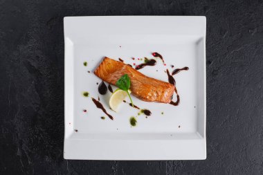 Beyaz tabakta soslu somon balığı