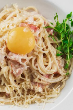 Lezzetli sağlıklı spagetti bolonez. Etli domates soslu makarna fesleğen yaprağı ve yuvarlak beyaz tabakta parmesan.
