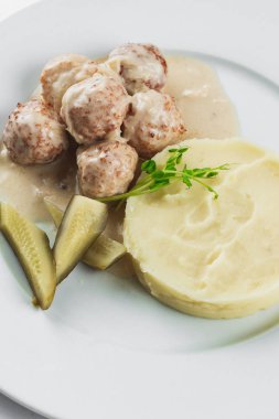 Beyaz tabakta patates püresi ve köfte.
