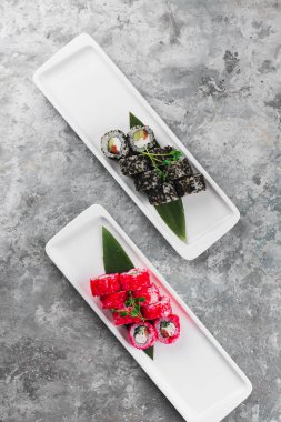 Beyaz tabakta lezzetli suşi ruloları, Japon yemekleri.