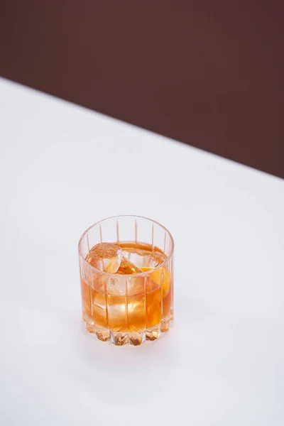 白いテーブルの上にガラスとウィスキーと氷のキューブ — ストック写真