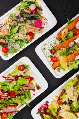 İnanılmaz lezzetli salataları olan beyaz tabaklar.