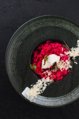 Krem peynirli pancar pilavı ve siyah tabakta parmesan.