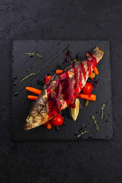 Grilled Branzino Red Sauce Vegetables Black Plate — Stock Photo, Image